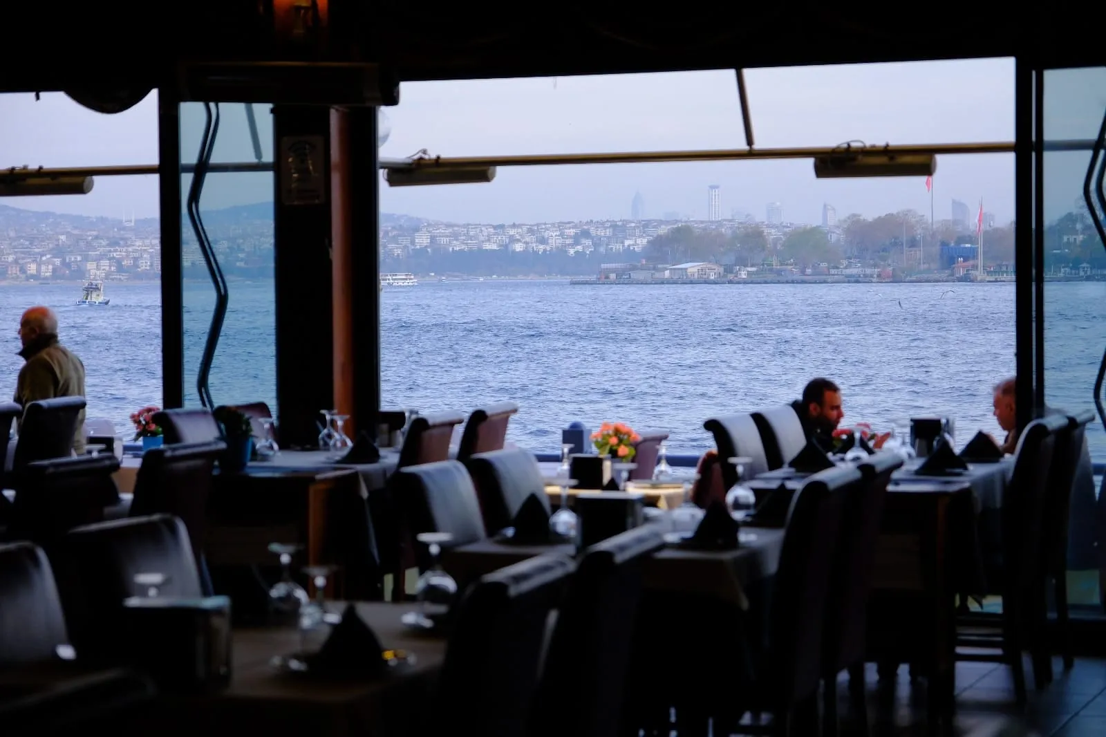 Akşamüstü pencere kenarındaki masalar ve deniz